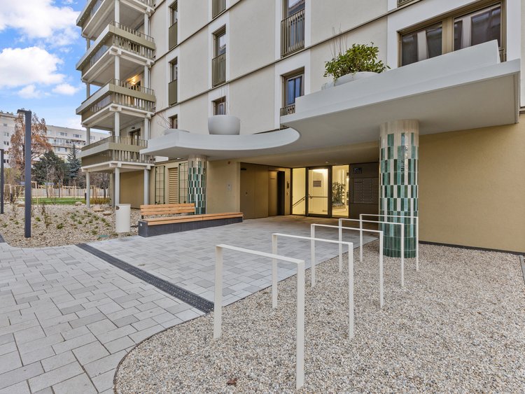 Entrance area of a modern residential and urban quarter in Vienna’s LeopoldQuartier, featuring high-quality architecture, landscaped outdoor spaces and barrier-free access.